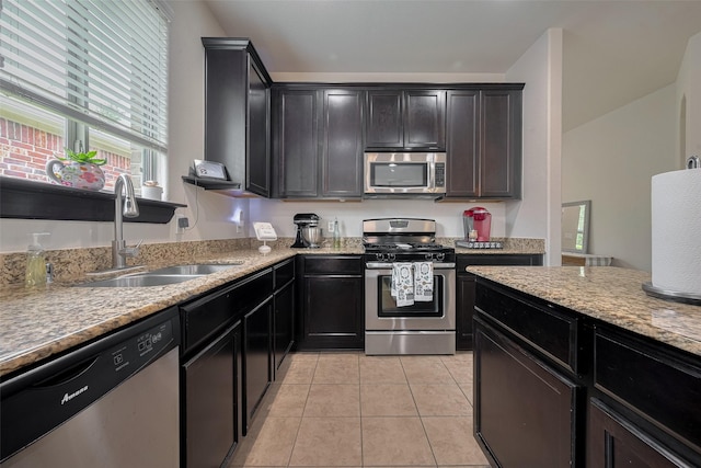5830 Acacia Rose Ct, Richmond, TX 77407 - kitchen with appliances with stainless steel finishes, light tile patterned flooring, and light stone counters
