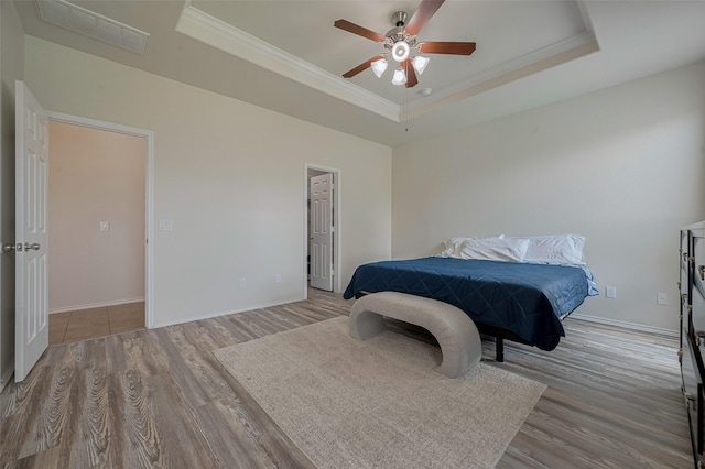 5830 Acacia Rose Ct, Richmond, TX 77407 - bedroom with a tray ceiling, wood finished floors, ornamental molding, and a ceiling fan