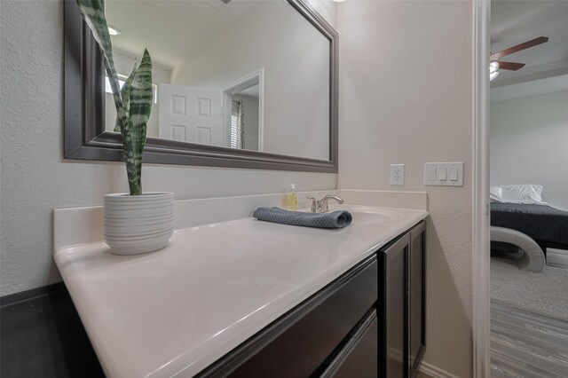 5830 Acacia Rose Ct, Richmond, TX 77407 - ensuite bathroom featuring double vanity, a textured wall, ceiling fan, and wood finished floors