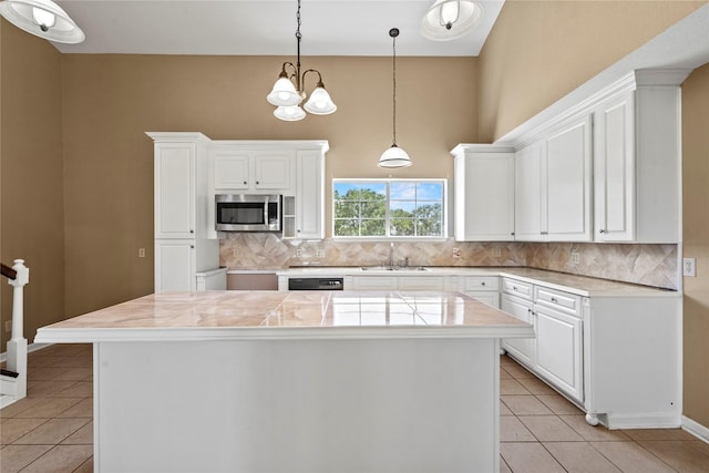 119 8th St, San Leon, TX 77539 - kitchen featuring stainless steel microwave, decorative backsplash, light tile patterned floors, and white cabinets