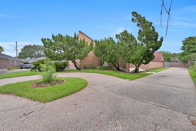 12 E Dansby Dr, Galveston, TX 77551 - view of property hidden behind natural elements featuring curved driveway and brick siding