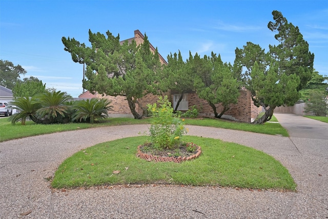 12 E Dansby Dr, Galveston, TX 77551 - obstructed view of property featuring curved driveway and brick siding