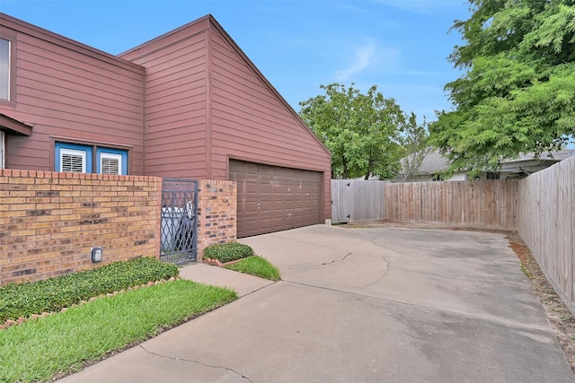 12 E Dansby Dr, Galveston, TX 77551 - garage featuring a gate and concrete driveway