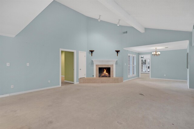12 E Dansby Dr, Galveston, TX 77551 - unfurnished living room featuring a tiled fireplace, a chandelier, beam ceiling, light colored carpet, and high vaulted ceiling