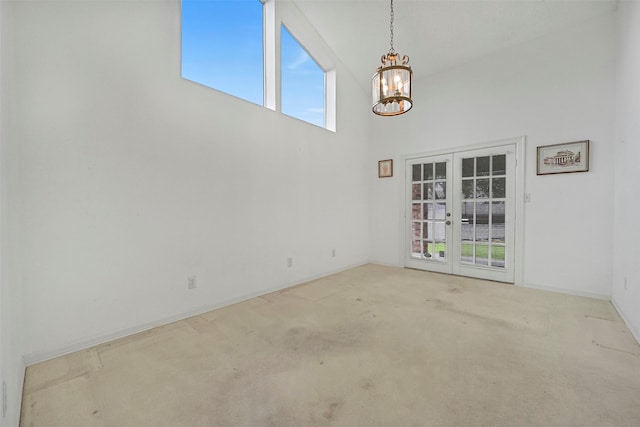 12 E Dansby Dr, Galveston, TX 77551 - carpeted spare room featuring french doors, a chandelier, and a high ceiling