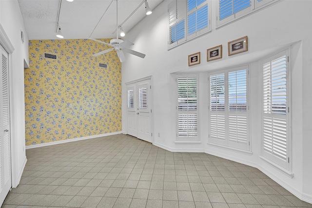 12 E Dansby Dr, Galveston, TX 77551 - unfurnished room with wallpapered walls, a ceiling fan, rail lighting, and tile patterned floors