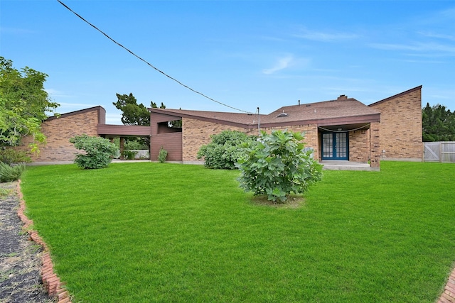 12 E Dansby Dr, Galveston, TX 77551 - rear view of house with brick siding and a yard