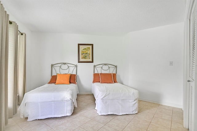 12 E Dansby Dr, Galveston, TX 77551 - bedroom featuring light tile patterned floors and a textured ceiling