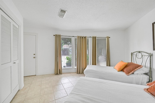 12 E Dansby Dr, Galveston, TX 77551 - bedroom featuring light tile patterned flooring and a textured ceiling