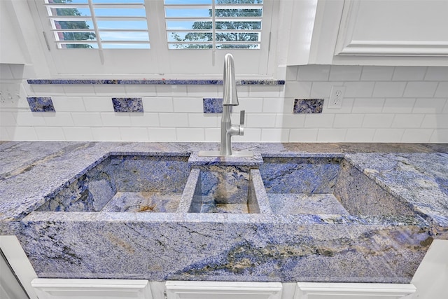 12 E Dansby Dr, Galveston, TX 77551 - kitchen view of white cabinets, tasteful backsplash, and stone countertops