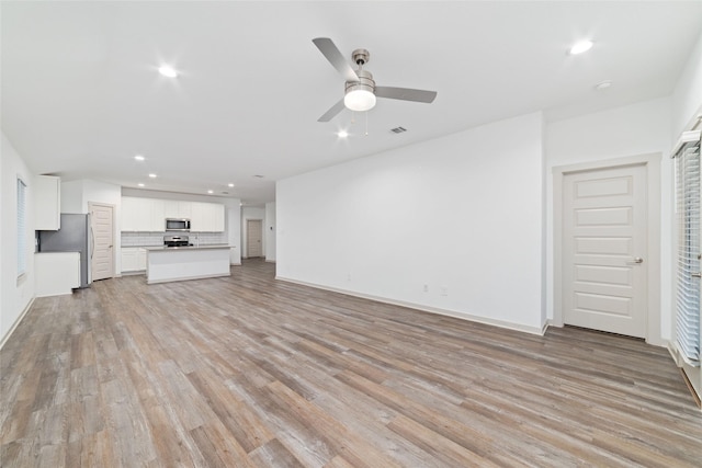 7002 Halifax Harvest Ln, Richmond, TX 77407 - unfurnished living room with recessed lighting, light wood-type flooring, and ceiling fan