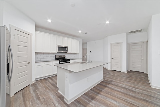 7002 Halifax Harvest Ln, Richmond, TX 77407 - kitchen featuring appliances with stainless steel finishes, light wood-style floors, decorative backsplash, recessed lighting, and white cabinets