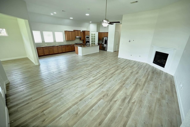 9002 Lacombe Ln, Tomball, TX 77375 - unfurnished living room featuring a fireplace, light wood-style floors, a ceiling fan, and recessed lighting