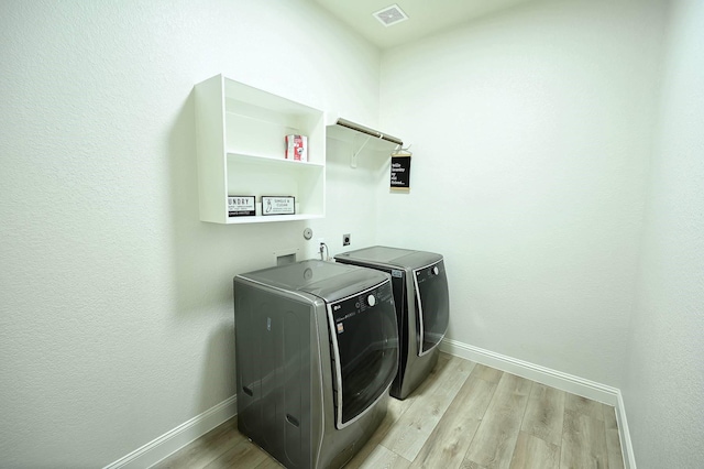 9002 Lacombe Ln, Tomball, TX 77375 - laundry area featuring light wood-style floors and washer and dryer