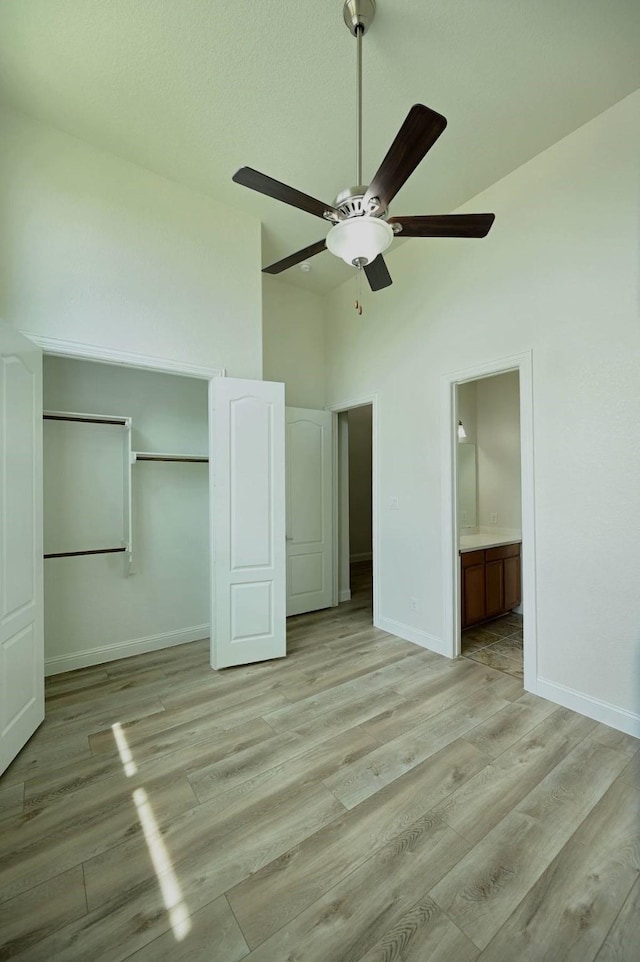 9002 Lacombe Ln, Tomball, TX 77375 - unfurnished bedroom featuring light wood finished floors, a closet, high vaulted ceiling, a ceiling fan, and ensuite bath