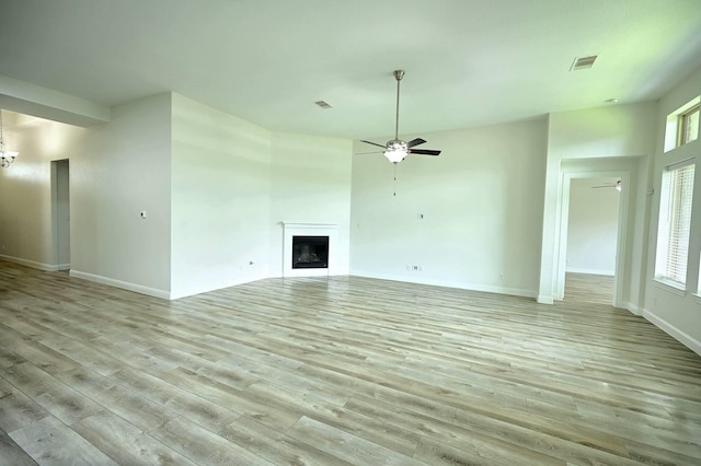 9002 Lacombe Ln, Tomball, TX 77375 - unfurnished living room with ceiling fan, light wood-type flooring, and a fireplace