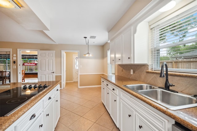 4117 Tilson Ln, Houston, TX 77080 - kitchen featuring black electric cooktop, light tile patterned flooring, pendant lighting, and white cabinets