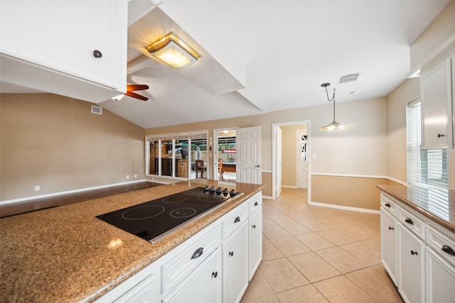 4117 Tilson Ln, Houston, TX 77080 - kitchen with black electric stovetop, ceiling fan, white cabinetry, light tile patterned floors, and vaulted ceiling