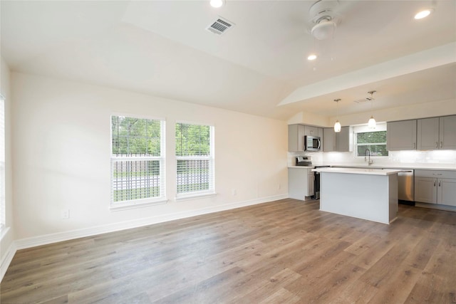 798 Fair St, Houston, TX 77088 - kitchen featuring gray cabinetry, appliances with stainless steel finishes, a center island, light countertops, and light wood-type flooring