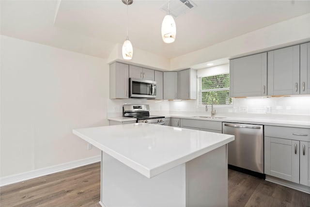 798 Fair St, Houston, TX 77088 - kitchen featuring stainless steel appliances, gray cabinetry, dark wood-style flooring, light countertops, and decorative backsplash