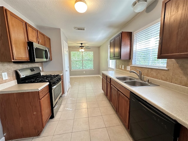 2827 Cypress Island Dr, Houston, TX 77073 - kitchen featuring stainless steel appliances, backsplash, light countertops, ceiling fan, and a textured ceiling