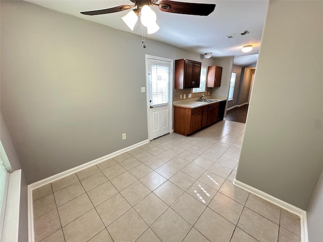 2827 Cypress Island Dr, Houston, TX 77073 - kitchen featuring light tile patterned floors, light countertops, ceiling fan, and dark brown cabinets