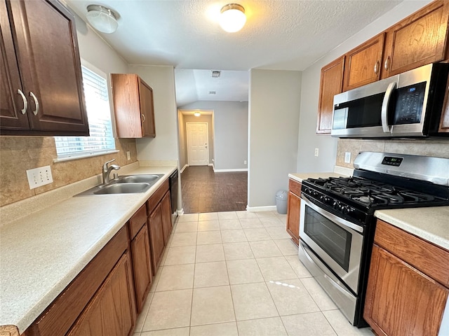 2827 Cypress Island Dr, Houston, TX 77073 - kitchen featuring appliances with stainless steel finishes, backsplash, light countertops, light tile patterned flooring, and a textured ceiling