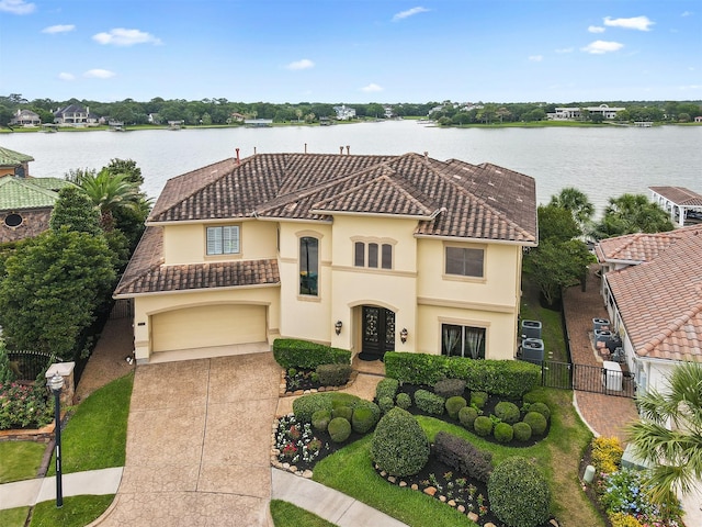 3045 S Island Dr, Seabrook, TX 77586 - mediterranean / spanish-style house featuring driveway, stucco siding, a tile roof, a water view, and a garage
