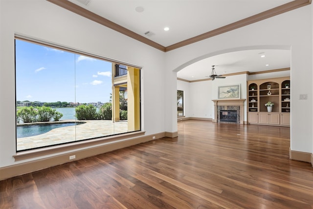 3045 S Island Dr, Seabrook, TX 77586 - unfurnished living room featuring ceiling fan, ornamental molding, wood finished floors, arched walkways, and a premium fireplace