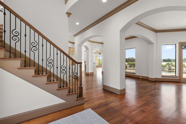 3045 S Island Dr, Seabrook, TX 77586 - foyer entrance featuring crown molding, wood finished floors, recessed lighting, arched walkways, and stairs