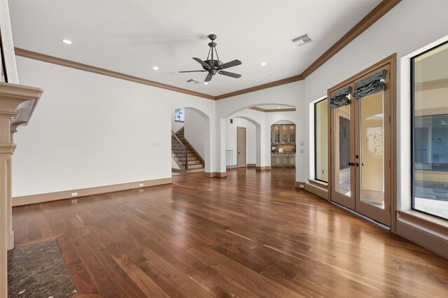3045 S Island Dr, Seabrook, TX 77586 - unfurnished living room featuring crown molding, arched walkways, wood finished floors, ceiling fan, and stairs
