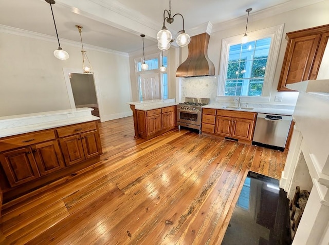 309 E Robert Toombs Ave, Washington, GA 30673 - kitchen with appliances with stainless steel finishes, wall chimney exhaust hood, brown cabinetry, light wood finished floors, and light countertops