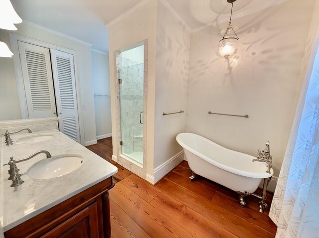 309 E Robert Toombs Ave, Washington, GA 30673 - bathroom featuring a shower stall, crown molding, hardwood / wood-style flooring, double vanity, and a freestanding bath
