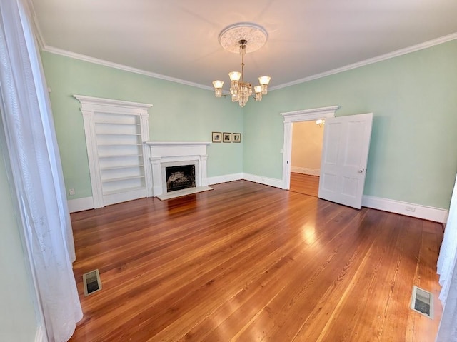 309 E Robert Toombs Ave, Washington, GA 30673 - unfurnished living room featuring a chandelier, ornamental molding, hardwood / wood-style floors, and a fireplace with flush hearth
