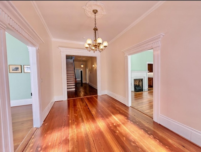 309 E Robert Toombs Ave, Washington, GA 30673 - unfurnished dining area featuring a fireplace with flush hearth, hardwood / wood-style flooring, a chandelier, crown molding, and stairway