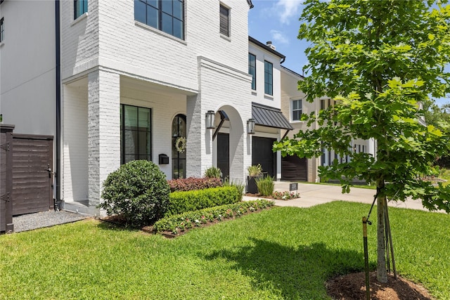 2324 Albans Rd, Houston, TX 77005 - view of front facade with an attached garage, a front yard, driveway, brick siding, and a standing seam roof