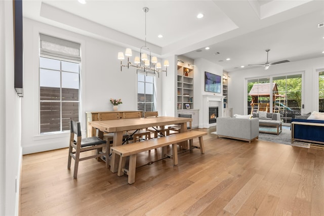 2324 Albans Rd, Houston, TX 77005 - dining area with light wood-type flooring, recessed lighting, a chandelier, a warm lit fireplace, and ceiling fan