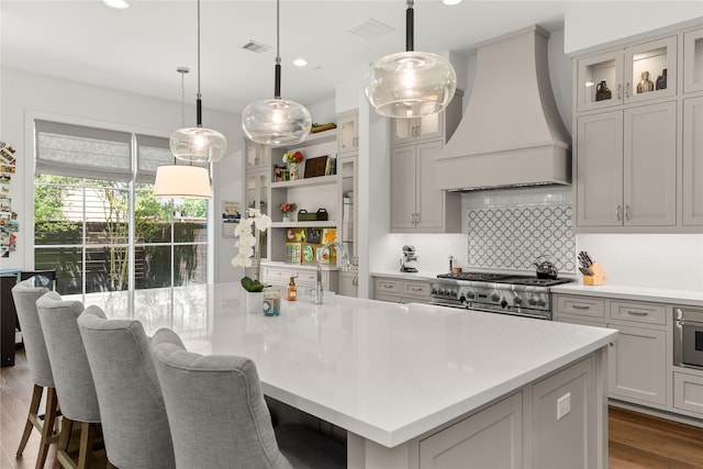 2324 Albans Rd, Houston, TX 77005 - kitchen featuring custom exhaust hood, light countertops, decorative backsplash, a breakfast bar area, and high end stove