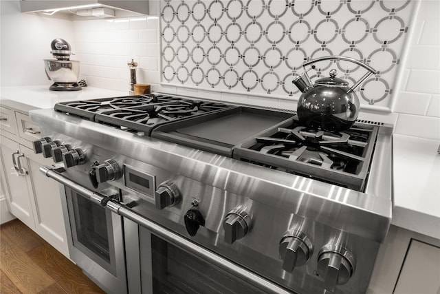 2324 Albans Rd, Houston, TX 77005 - kitchen view of range with two ovens, decorative backsplash, white cabinetry, wood finished floors, and light countertops