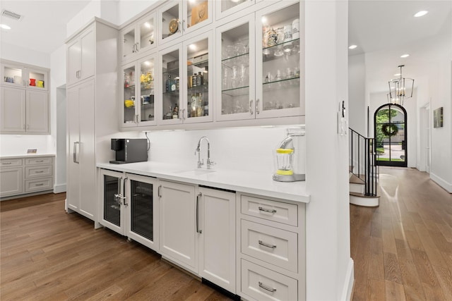 2324 Albans Rd, Houston, TX 77005 - bar area featuring wood finished floors, decorative backsplash, recessed lighting, wine cooler, and stairway