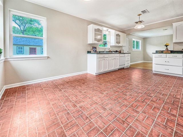 723 Pas Trl, Houston, TX 77336 - kitchen with brick patterned flooring, dark countertops, white cabinets, glass insert cabinets, and ornamental molding