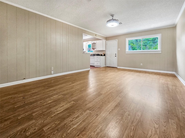 723 Pas Trl, Houston, TX 77336 - unfurnished living room featuring crown molding, wood finished floors, and a textured ceiling