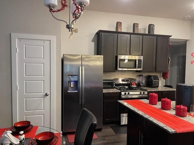 17583 Longwood Trace Ln, New Caney, TX 77357 - kitchen with stainless steel appliances, dark wood-type flooring, light countertops, and a chandelier