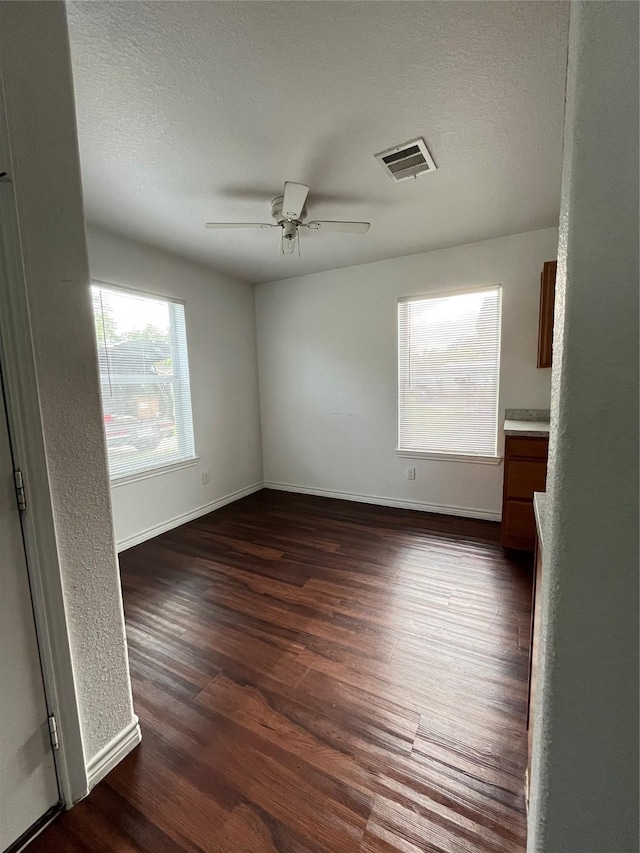 1019 Avenue E Ave E, Rosenberg, TX 77471 - spare room with dark wood finished floors, a ceiling fan, and a textured ceiling