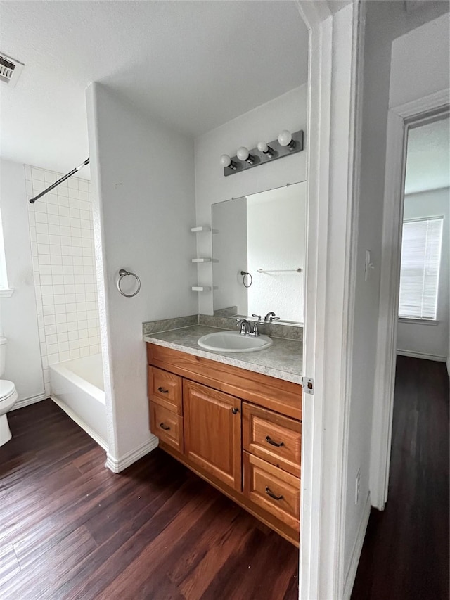 1019 Avenue E Ave E, Rosenberg, TX 77471 - full bath with vanity, wood finished floors, and tub / shower combination