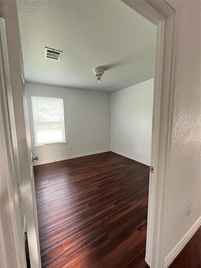 1019 Avenue E Ave E, Rosenberg, TX 77471 - empty room with dark wood-style floors and a textured ceiling