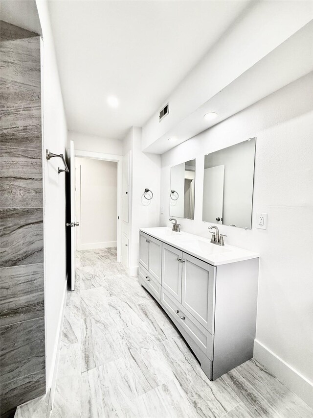 4015 Leeshire Dr, Houston, TX 77025 - bathroom with double vanity, recessed lighting, and marble look tile flooring