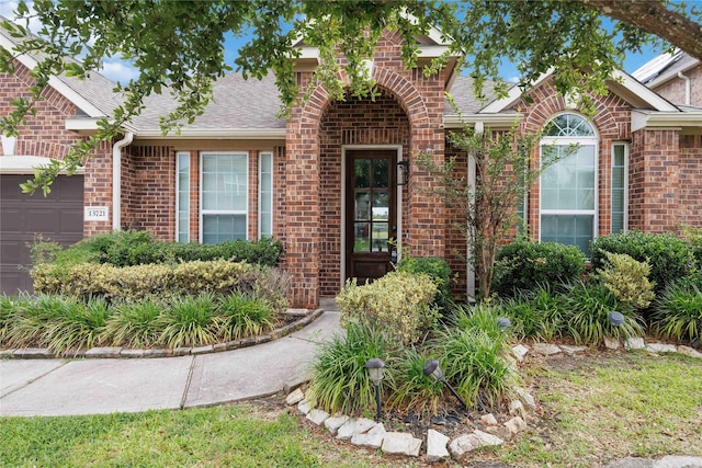 13721 Northline Lake Dr, Houston, TX 77044 - view of front of home with brick siding, an attached garage, and a shingled roof