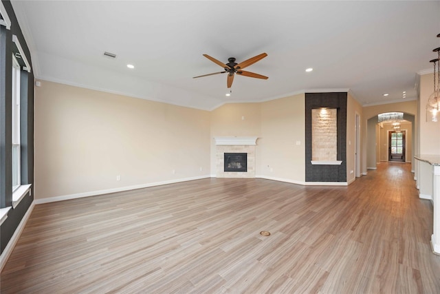 13721 Northline Lake Dr, Houston, TX 77044 - unfurnished living room with a glass covered fireplace, ceiling fan, recessed lighting, light wood-style flooring, and arched walkways