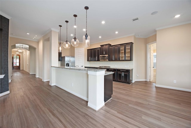 13721 Northline Lake Dr, Houston, TX 77044 - kitchen featuring appliances with stainless steel finishes, arched walkways, tasteful backsplash, light wood finished floors, and crown molding